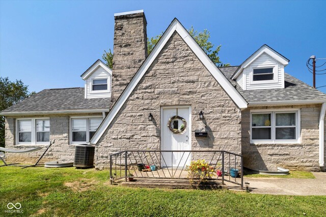 view of front facade with central AC unit and a front yard