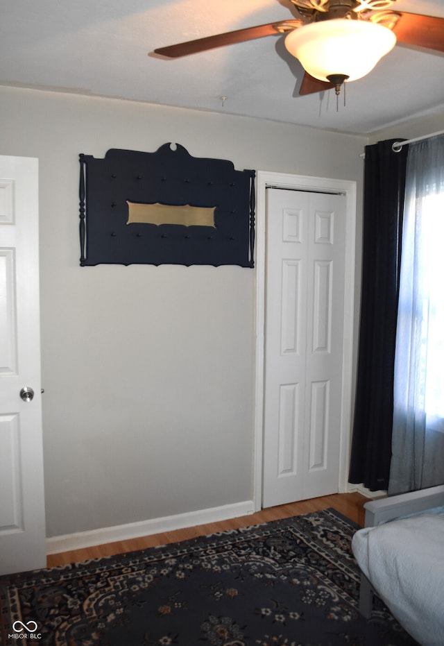 bedroom featuring ceiling fan, a closet, and hardwood / wood-style flooring