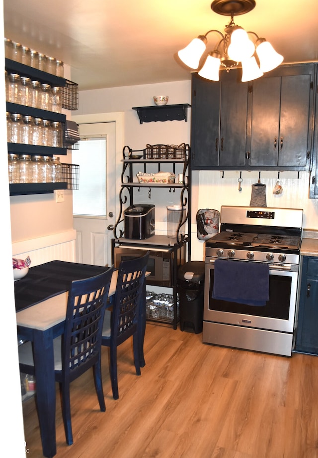 kitchen featuring light wood-type flooring, gas range, and an inviting chandelier