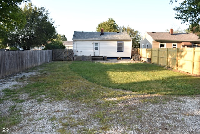 rear view of house featuring a yard