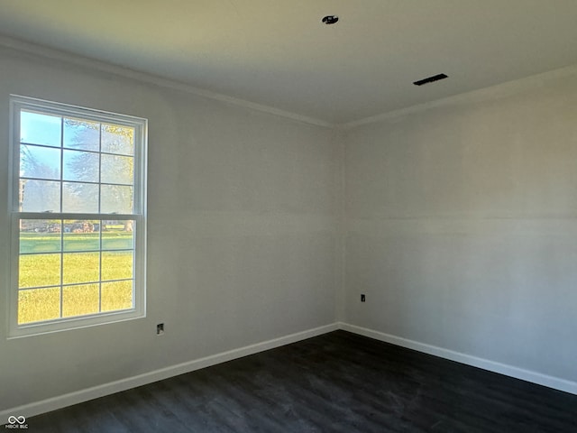 empty room with dark hardwood / wood-style flooring and crown molding