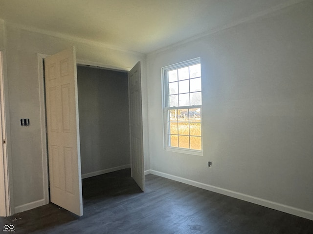 unfurnished bedroom featuring a closet and dark hardwood / wood-style flooring