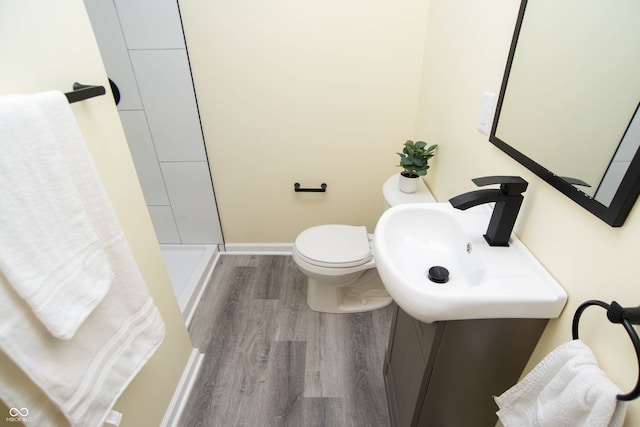 bathroom with hardwood / wood-style floors, toilet, and a shower