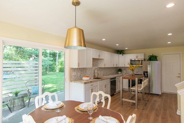 dining area featuring sink and dark hardwood / wood-style floors