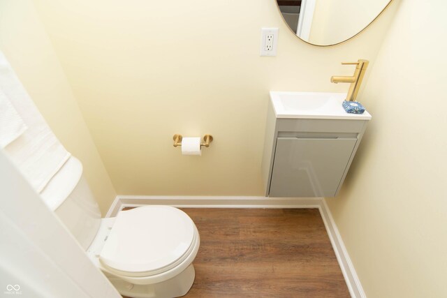 bathroom with hardwood / wood-style floors, vanity, and toilet