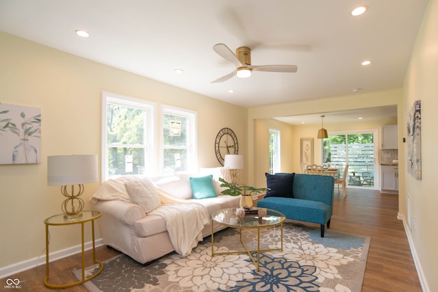 living room featuring dark hardwood / wood-style floors, a healthy amount of sunlight, and ceiling fan