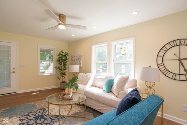 living room with ceiling fan and dark wood-type flooring