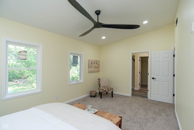 carpeted bedroom with multiple windows, ceiling fan, and lofted ceiling