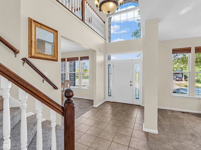 entryway featuring an inviting chandelier and light carpet