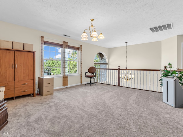 sitting room with light carpet, a textured ceiling, and an inviting chandelier