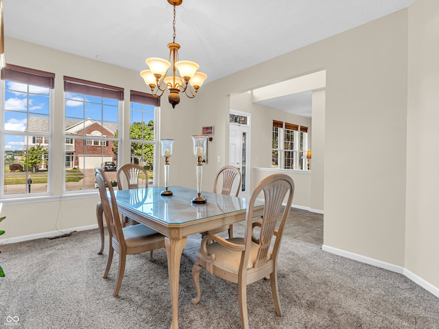 dining area with a notable chandelier and carpet flooring