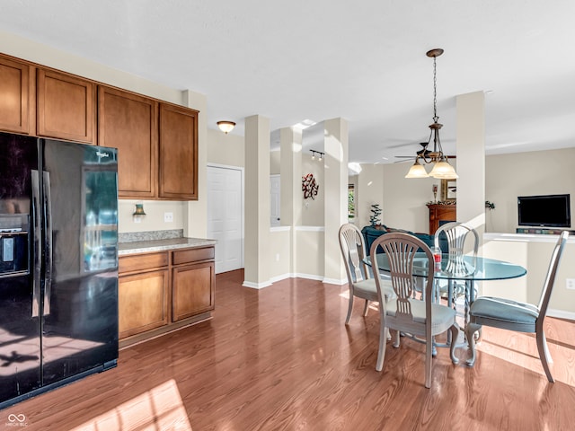 kitchen with black fridge, hardwood / wood-style floors, ceiling fan, and decorative light fixtures