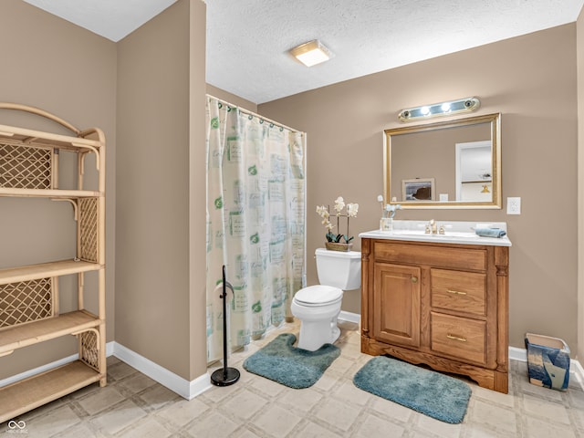 bathroom with vanity, toilet, a shower with curtain, and a textured ceiling