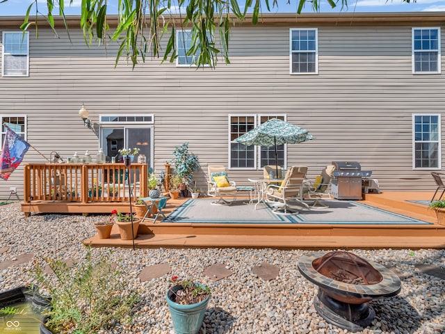 rear view of house with a fire pit and a deck