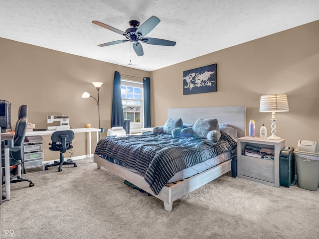 bedroom with ceiling fan, a textured ceiling, and carpet floors