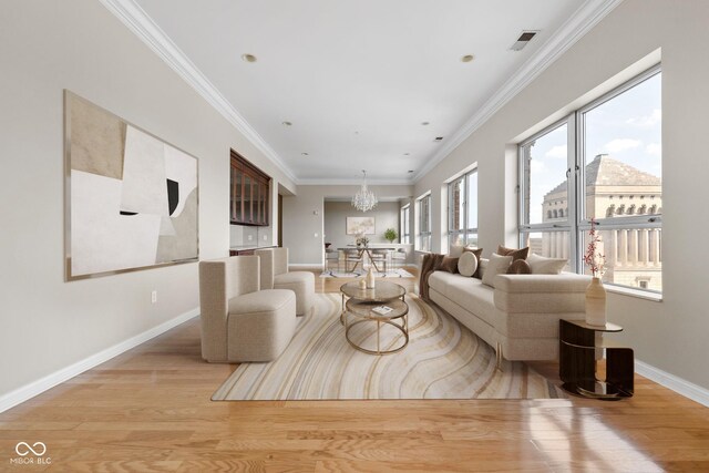 living room featuring light wood-type flooring, crown molding, and an inviting chandelier