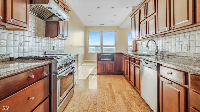 kitchen with light hardwood / wood-style flooring, backsplash, light stone counters, and appliances with stainless steel finishes