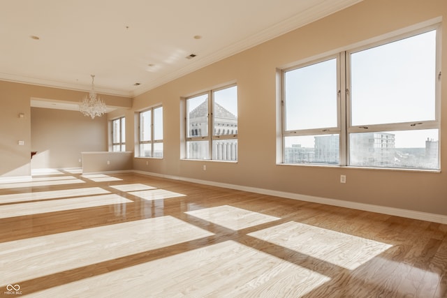 unfurnished room with light wood-type flooring, crown molding, and a notable chandelier