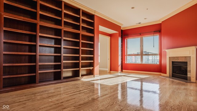 unfurnished living room with light hardwood / wood-style floors and ornamental molding