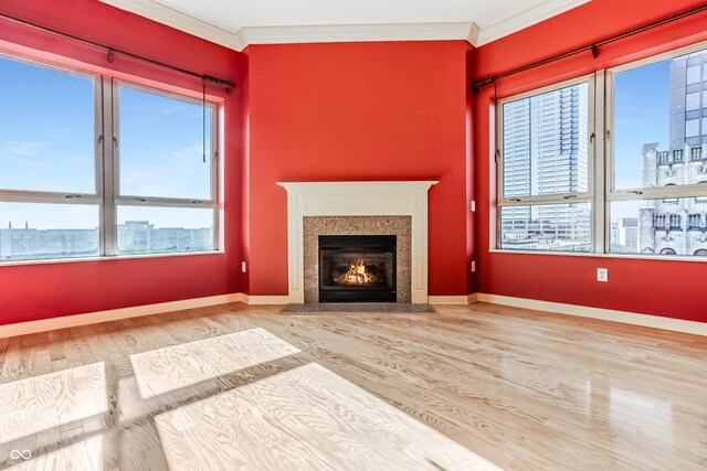 unfurnished living room with a premium fireplace, ornamental molding, and hardwood / wood-style flooring