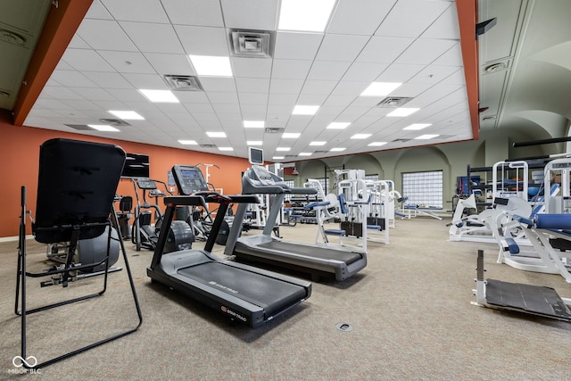 workout area with a paneled ceiling and carpet