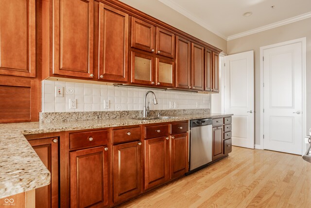 kitchen featuring light stone countertops, dishwasher, tasteful backsplash, sink, and light wood-type flooring