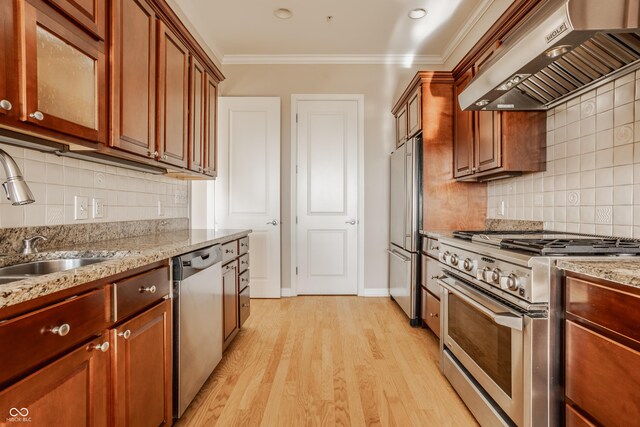 kitchen with light hardwood / wood-style flooring, backsplash, stainless steel appliances, range hood, and light stone countertops