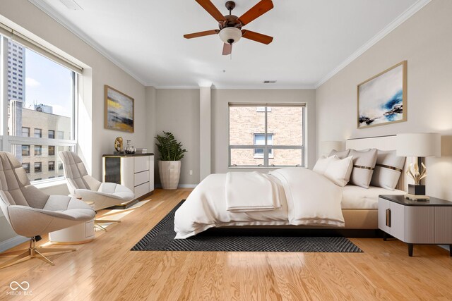 bedroom featuring ceiling fan, ornamental molding, and light hardwood / wood-style floors