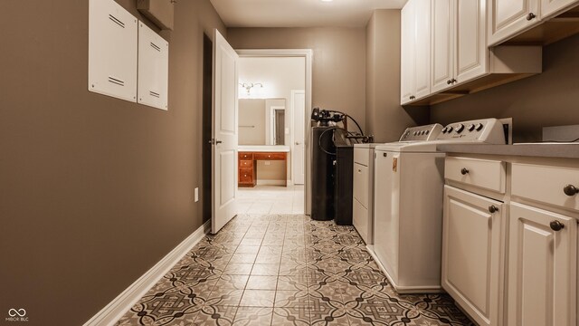 washroom with washing machine and dryer, cabinets, and light tile patterned flooring