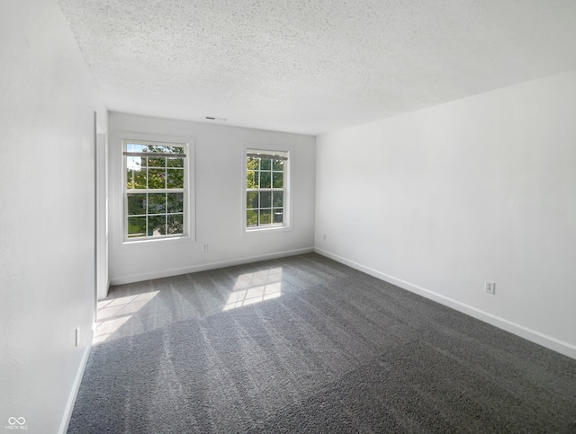 carpeted empty room featuring a textured ceiling