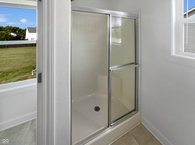 bathroom with tile patterned floors and a shower with door