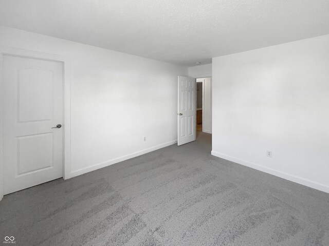 carpeted empty room with a textured ceiling