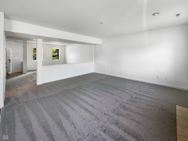 unfurnished living room with dark colored carpet