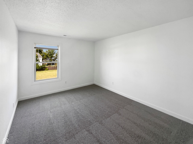 carpeted spare room with a textured ceiling