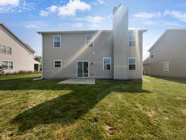 rear view of house with a patio and a lawn