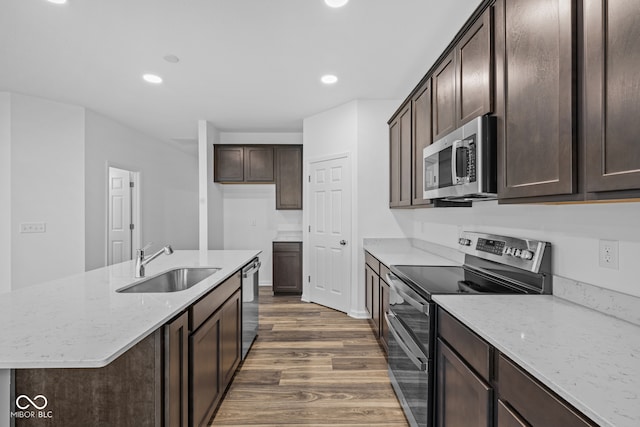 kitchen with stainless steel appliances, dark hardwood / wood-style floors, dark brown cabinetry, and sink