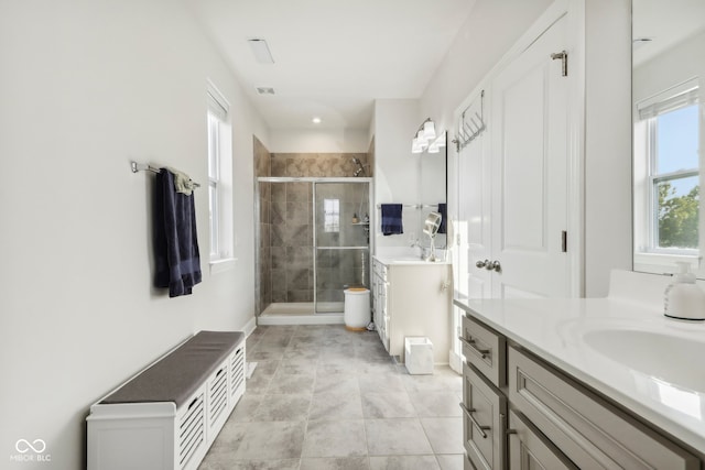 bathroom with tile patterned flooring, an enclosed shower, and vanity