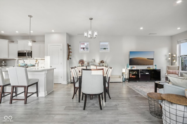 dining room with light hardwood / wood-style flooring and a chandelier