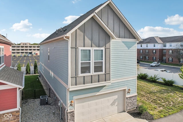 view of side of home featuring central AC and a garage