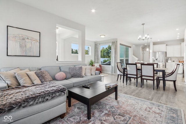 living room featuring light hardwood / wood-style flooring and an inviting chandelier