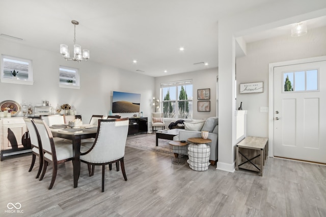 dining area with an inviting chandelier and light hardwood / wood-style flooring