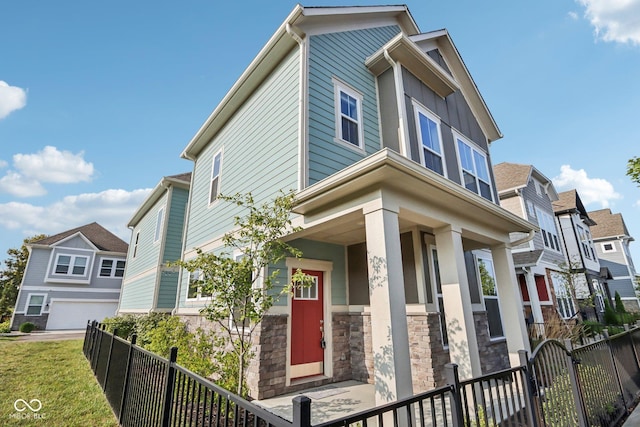 view of front of home featuring a garage, stone siding, and fence