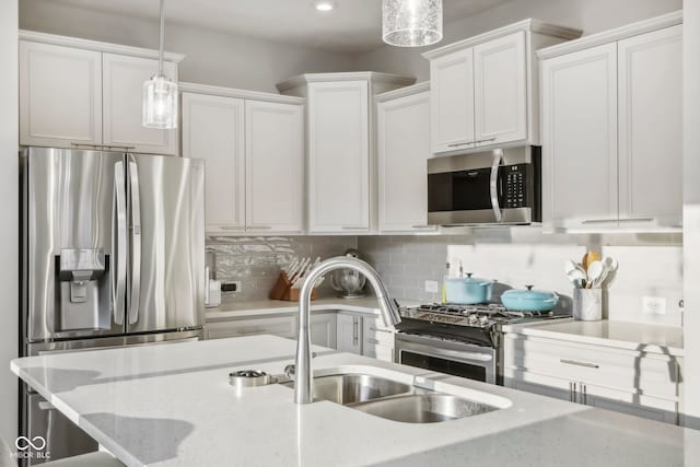 kitchen with white cabinetry, backsplash, stainless steel appliances, and hanging light fixtures