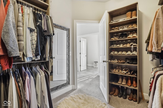 spacious closet featuring light colored carpet