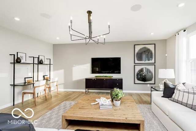 living room with an inviting chandelier and light hardwood / wood-style floors