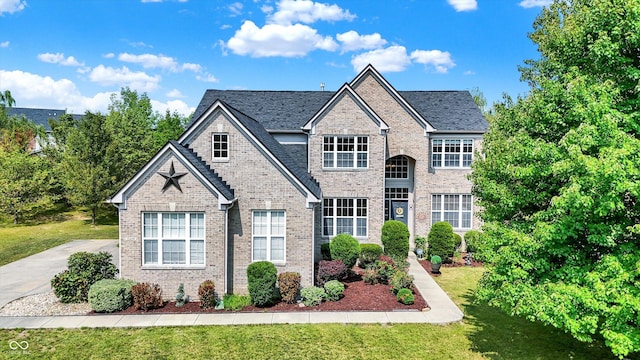 traditional home with brick siding, driveway, and a front lawn