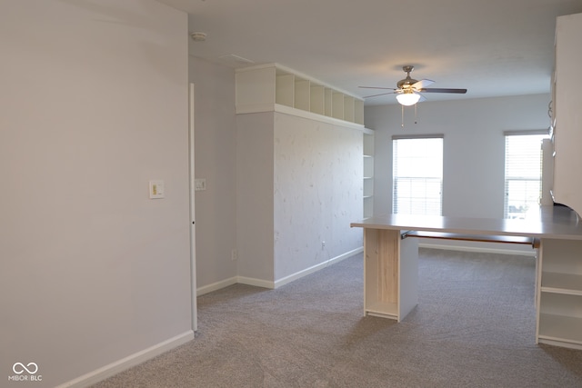 kitchen with kitchen peninsula, ceiling fan, and carpet