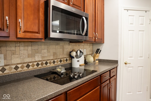 kitchen with black electric stovetop and decorative backsplash