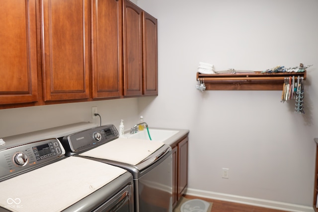 clothes washing area with cabinets, separate washer and dryer, and sink