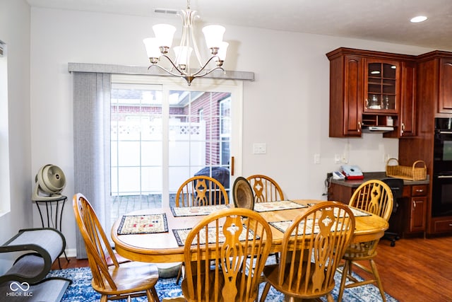 dining room featuring dark wood-type flooring, plenty of natural light, and an inviting chandelier